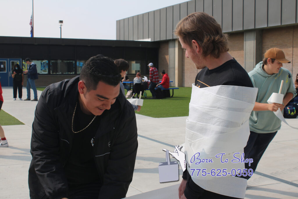 Ruben Garcia and Jason Riley participate in the Mummy Wrap down lunchtime activity. /Emily Valdez • The Brand