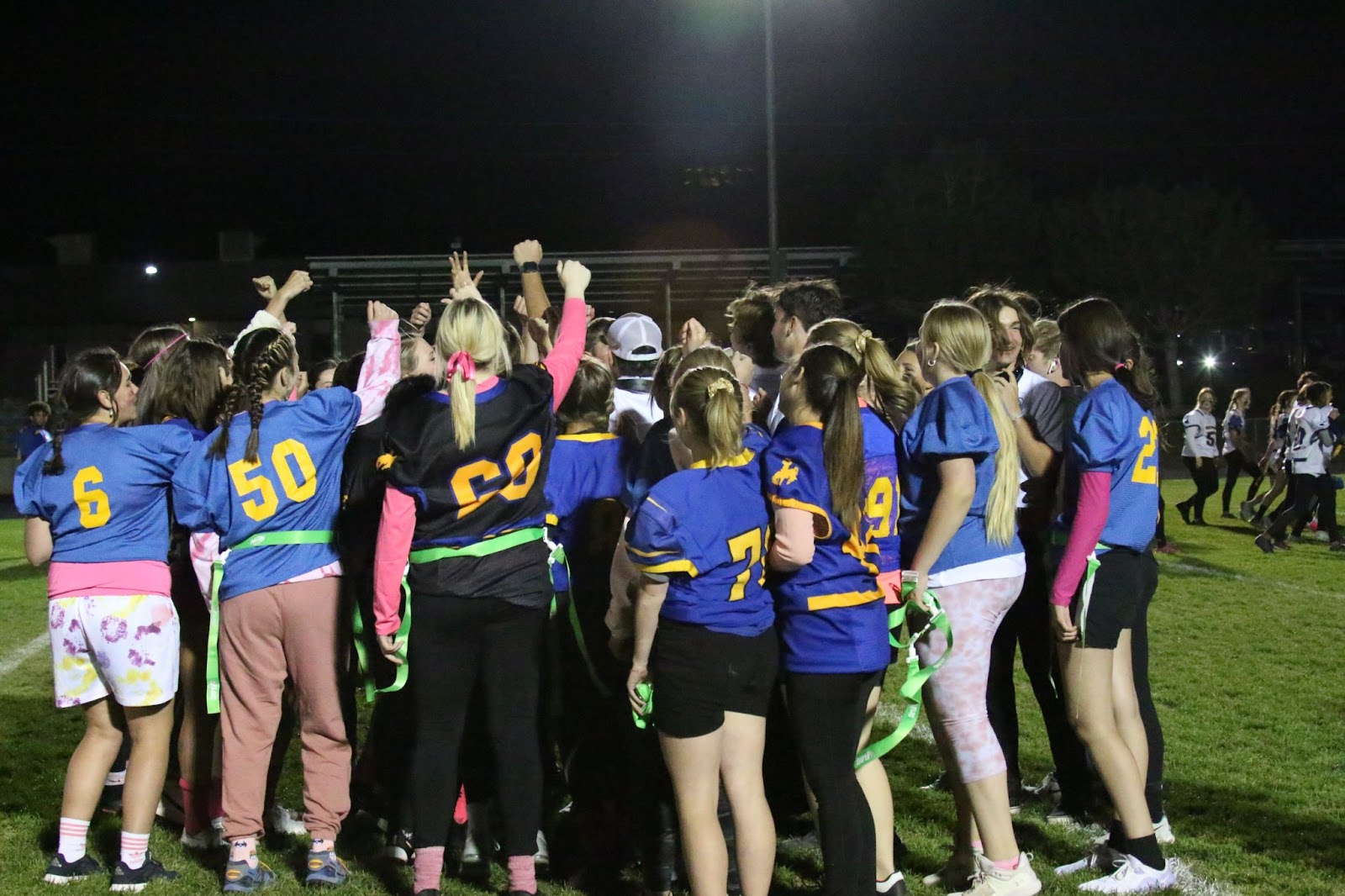Freshmen and seniors stand together before going out onto the field to play a game of Powderpuff football. /Jovi Anderson • The Brand