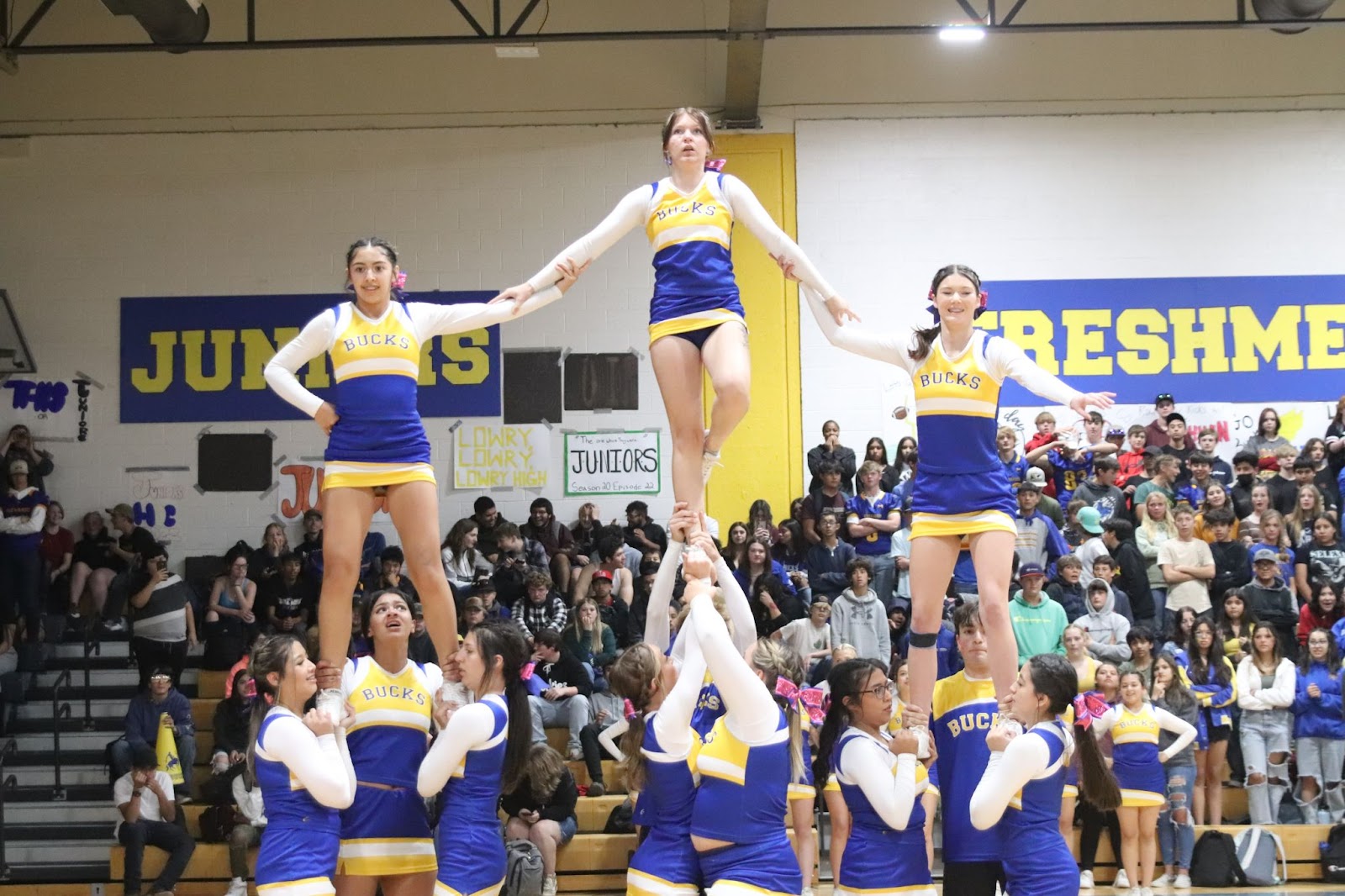 Varsity cheerleaders put on a show during the Homecoming Pep assembly to energize the crowd for the upcoming game. /Elizabeth Carrillo • The Brand