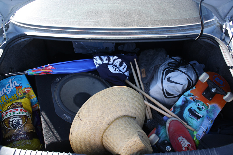 Miguel Zepeda’s trunk is filled with many random items including: water balloons, snacks, a speaker, a skateboard, a beanie, extra shoes, extra clothes, a sports-bag, and drumsticks./Jolyn Garcia • The Brand