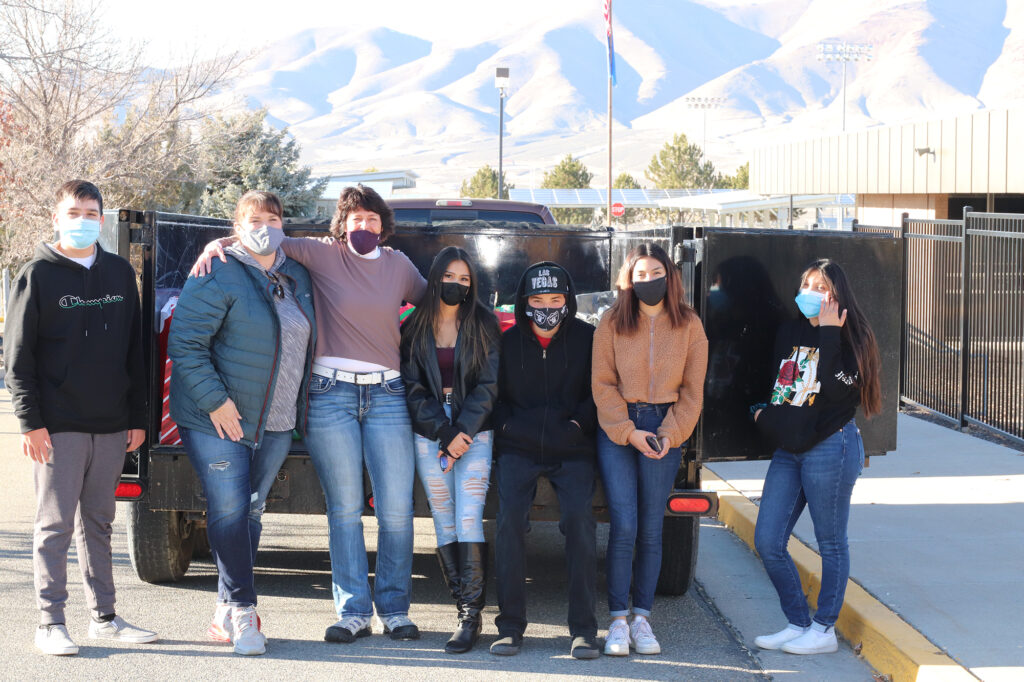 Representatives from FCAA, Mrs. Alexis Mattson and students stand in front of a trailer loaded with presents./Kiley Dayton • Lowry Multimedia Communication