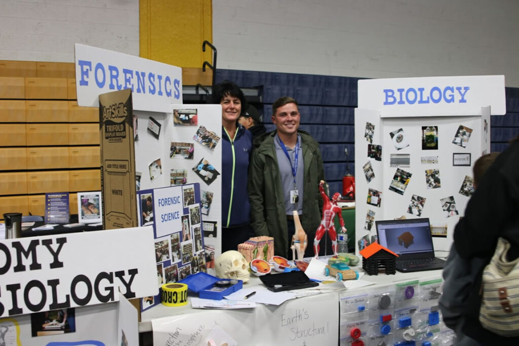 Mrs.Alexis Mattson and Mr.Calvin Connors standing next to there booth for the biology section./Octavio Ruiz • The Brand