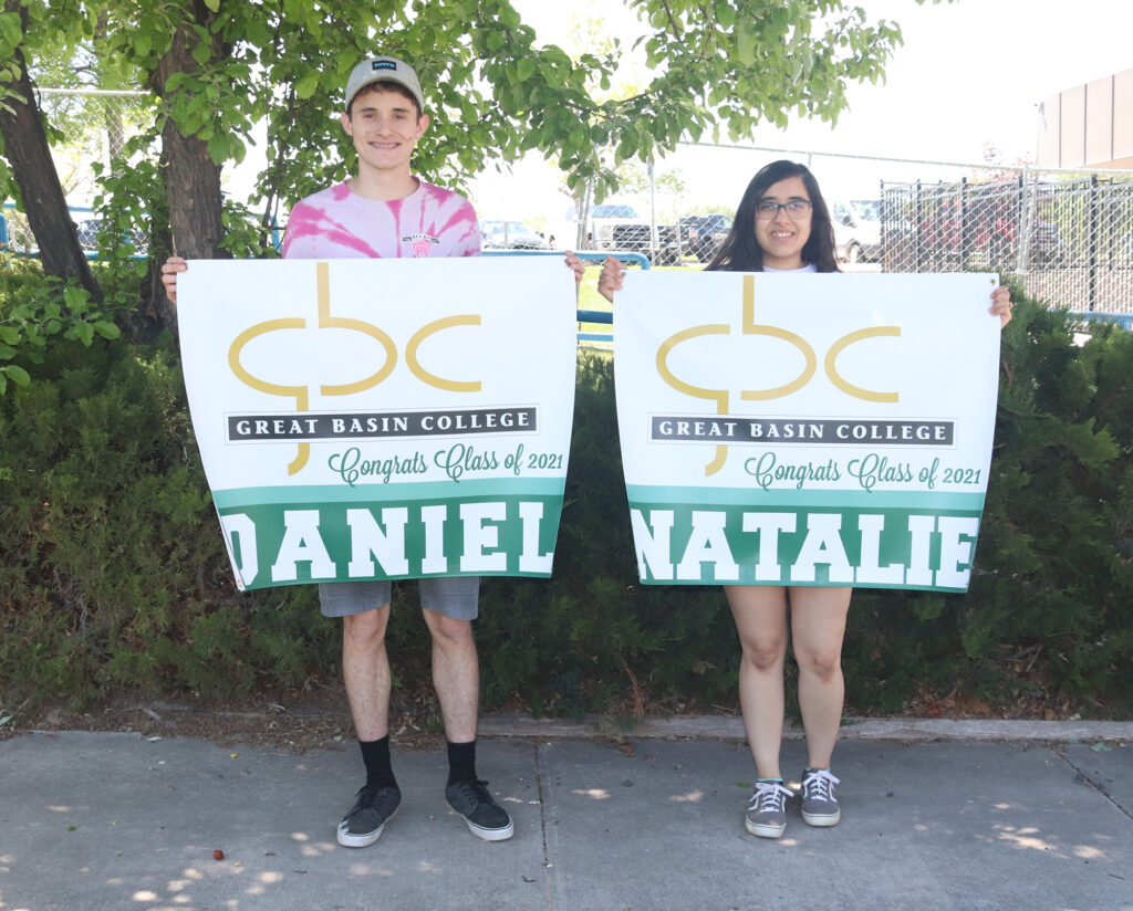 Natalie Contreas and Daniel Fernandez holding graduation signs from GBC. /Ron Espinola • The Brand