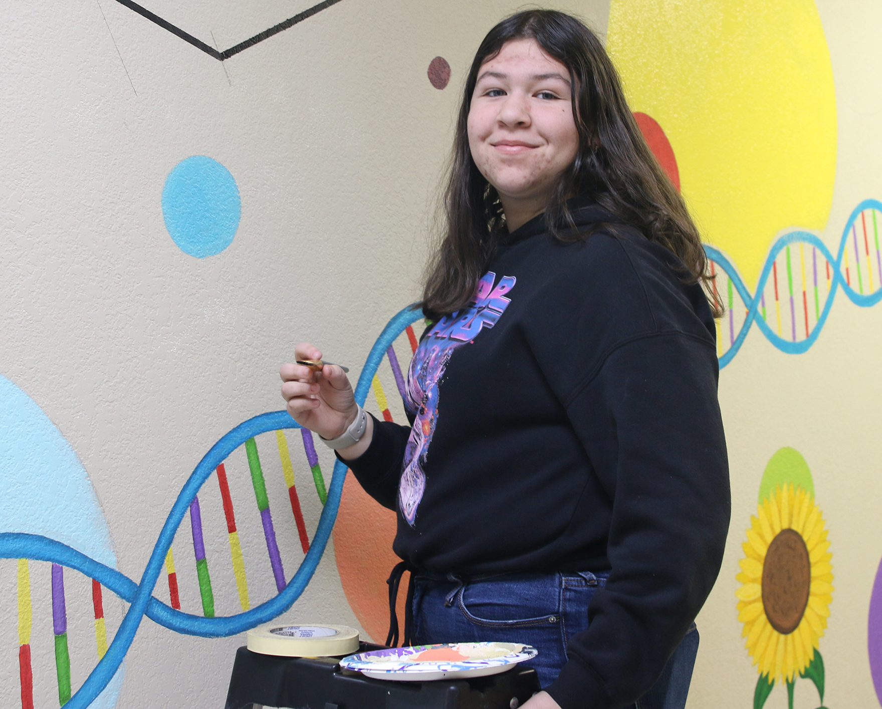 Arianna Ruiz works on a science mural. /Ariana Perez • The Brand