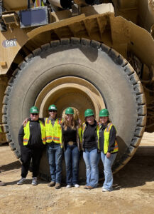 Students take a break on their tour to pose in front of some mining equipment./ Courtesy • Cherese Fifield