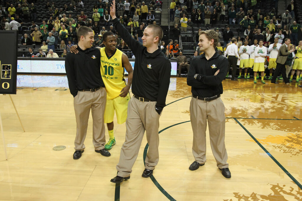 Davey Walton (Left) is hugged by an Oregon basketball player as the team managers are recognized before a game. /Courtesy • Jamie Walton