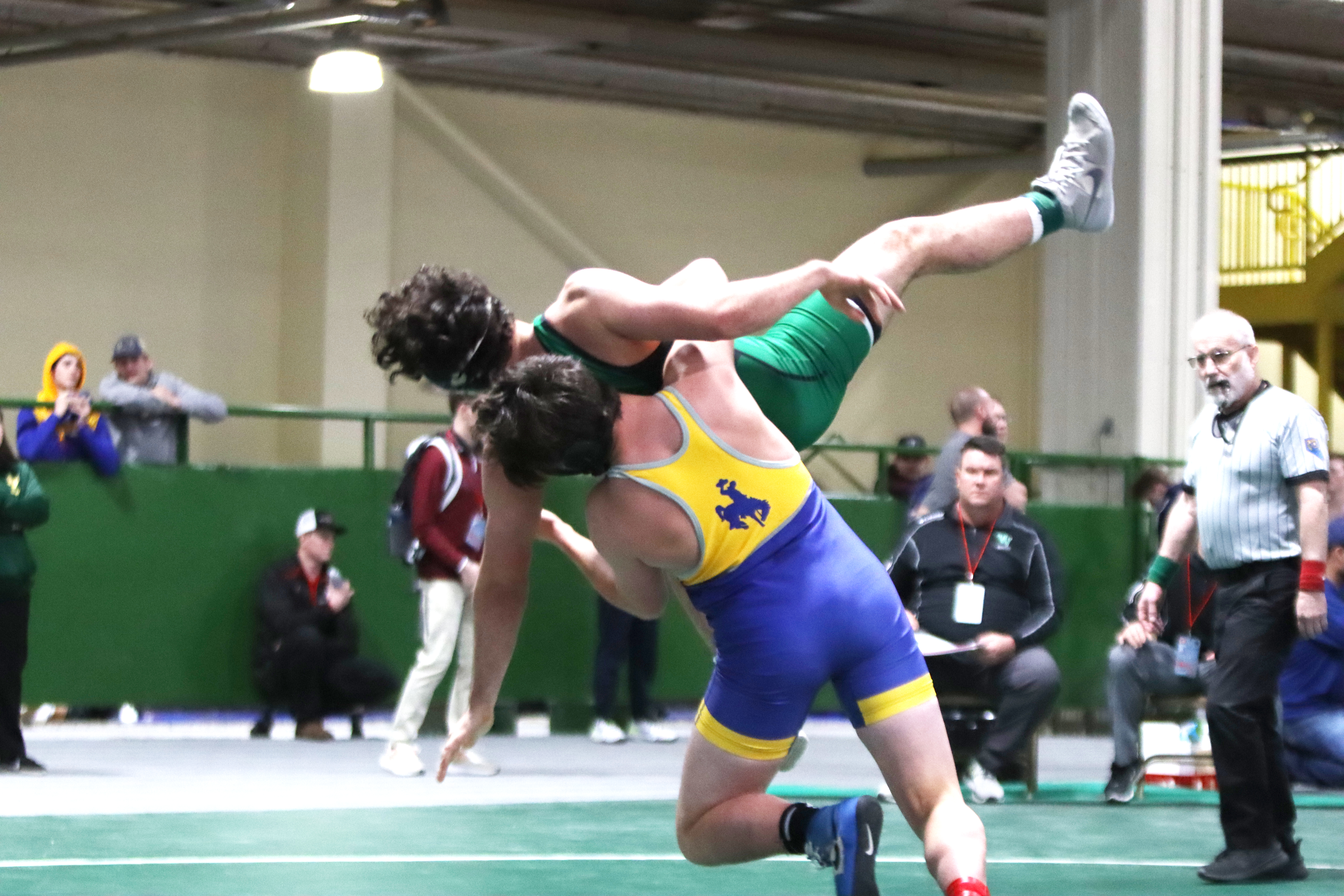 Brayden Dennis lifts his opponent off the mat and scores a takedown at the state tournament. /Olivia Espinola • The Brand 
