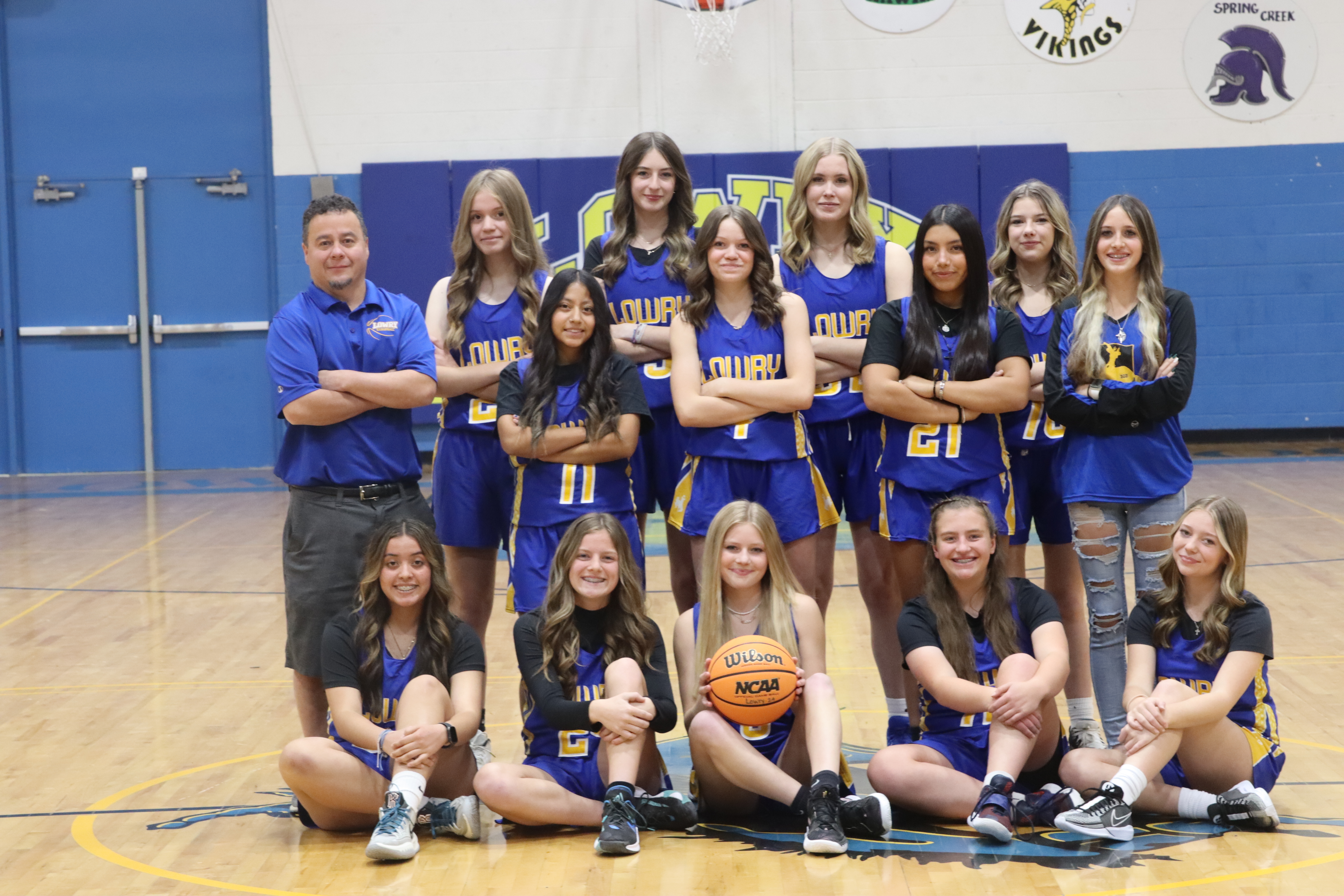 Freshman Basketball Team smiles and poses for their team photo / Olivia Espinola • The Brand