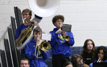 Martin Dockter, standing on the right ,plays the trumpet during a basketball game in the student section./ Ron Espinola • The Brand