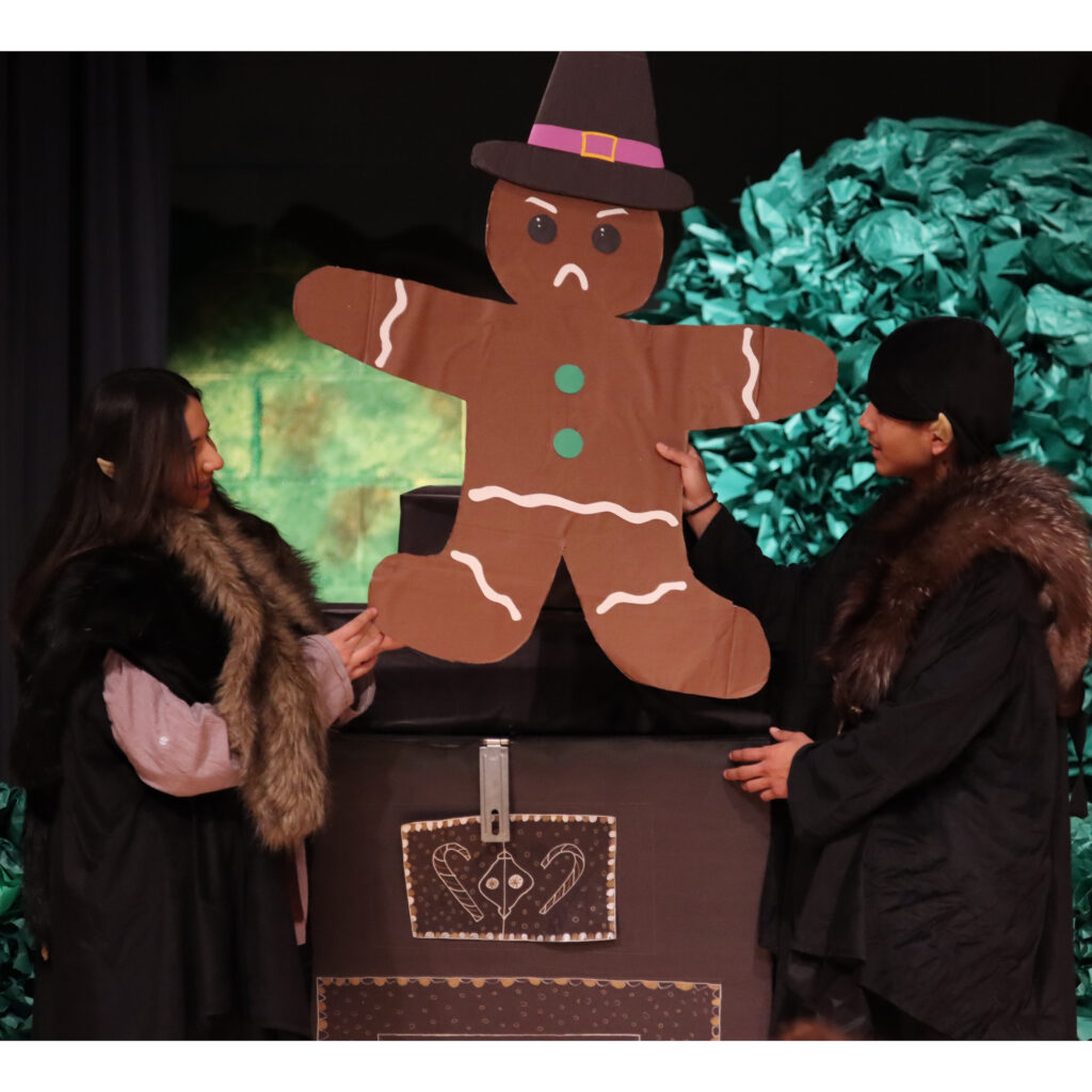 Julianna Carrillo and Rogelio Hernandez Ruiz pull out the gingerbread Witch as a cookie from the stove / The Brand • Ron Espinola