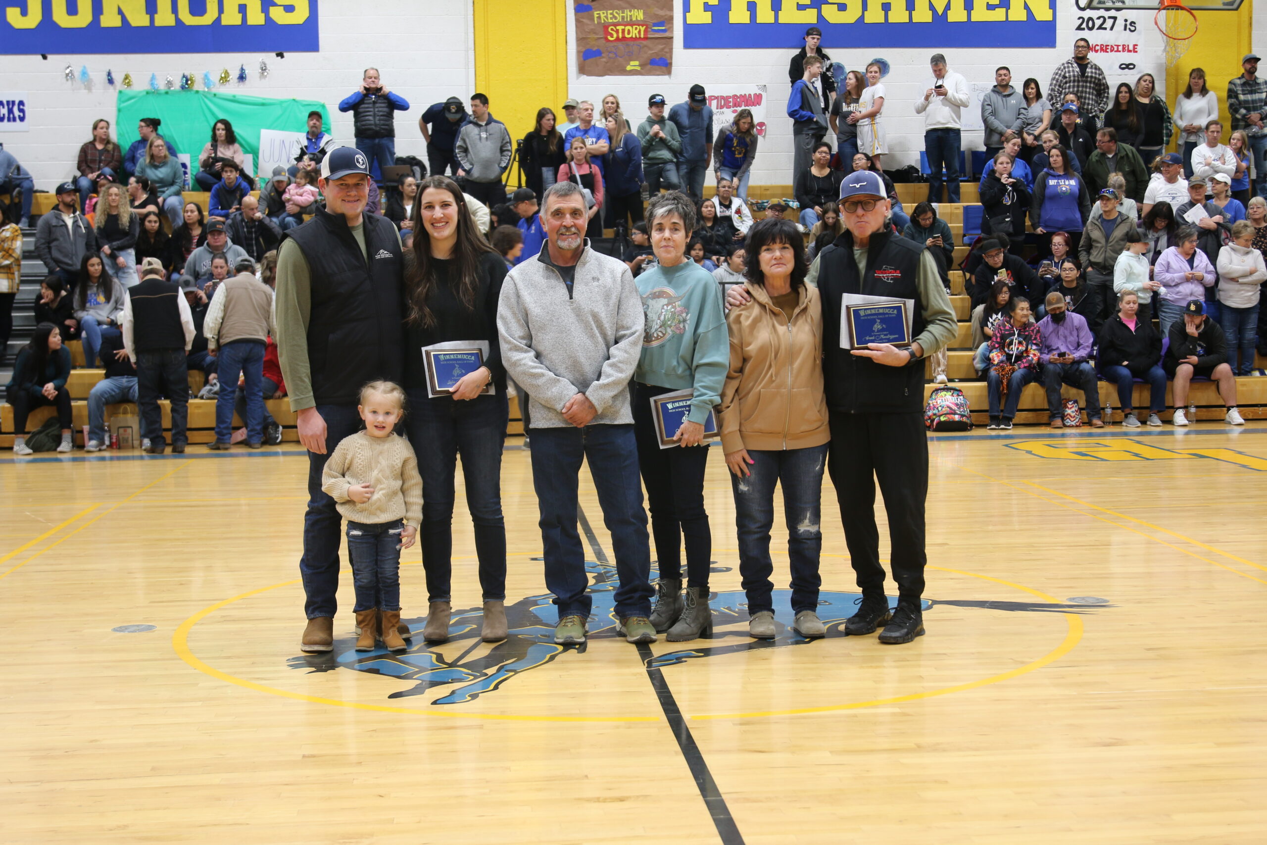 Julia Dufurrena (second from left) with her husband Chris Dendary and daughter, the parents of Mitch Pollock (Kelly and Tammy Pollock) and Frank Maestrejuan (far right) with his wife in attendance at the Hall of Fame induction at half time of the varsity girls game against Fernley on February 10, 2024. /Olivia Espinola • The Brand