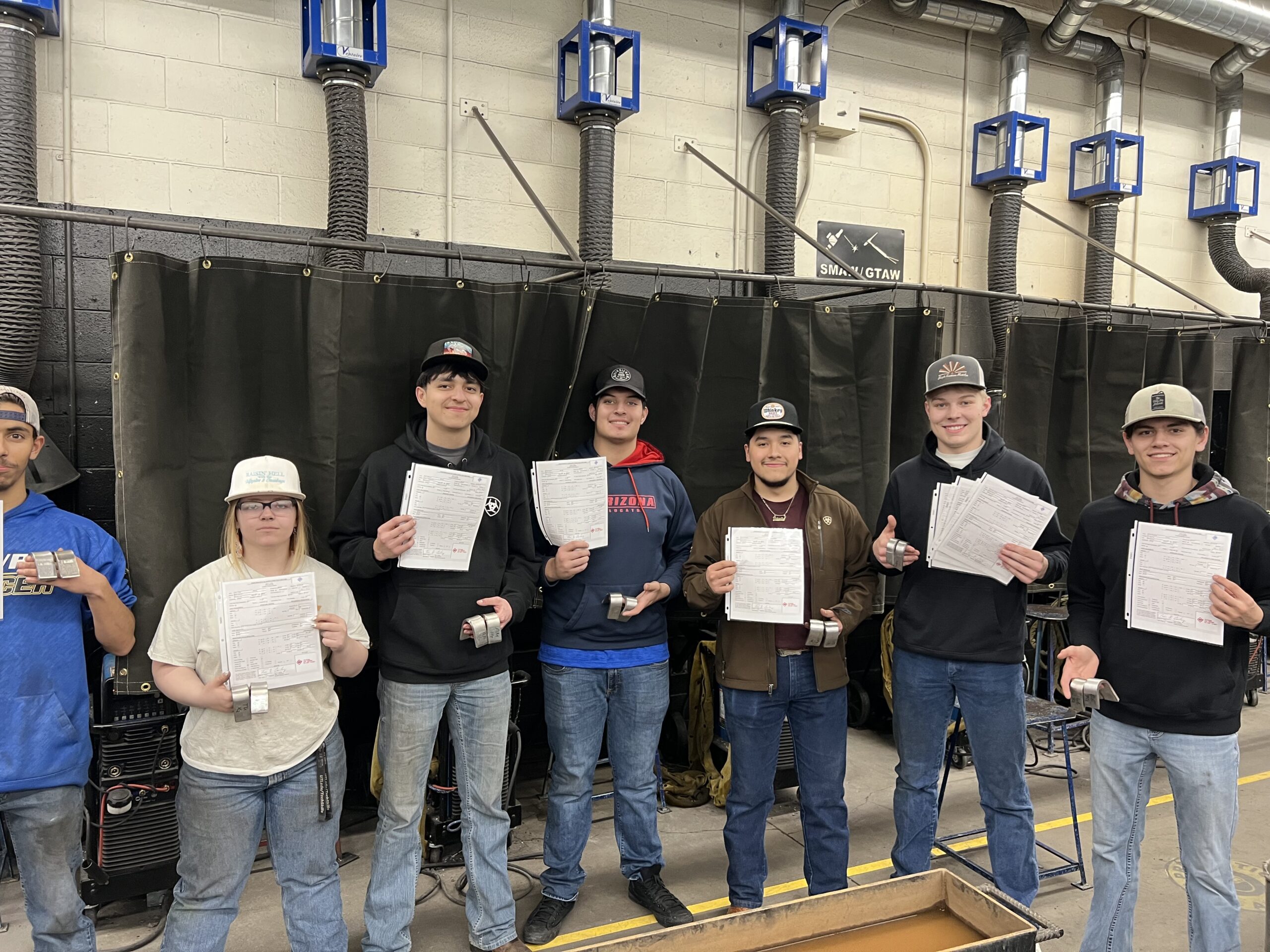 Timothy Patchen, Tesa Urrutia, Anton Mendoza, Nomar Aguirre, Roberto Barcenas, Dempsey Jenkins and Landon Esquivel. Holding their welding certificates after they spent the day earning them. / Courtesy • Andrew Meyer 