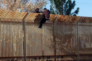 090317-N-5253T-016 DOUGLAS, Ariz. (March 17, 2009) Two men scale the border fence into Mexico a few hundred yards away from where Seabees from Naval Mobile Construction Battalions (NMCB) 133 and NMCB-14 are building a 1,500 foot-long concrete-ined drainage ditch and a 10 foot-high wall to increase security along the U.S. and Mexico border in Douglas, Ariz. (U.S. Navy photo by Steelworker 1st Class Matthew Tyson/Released)