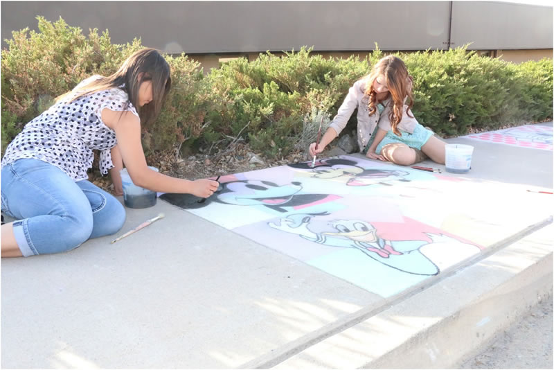 Students work on their sidewalk art./Ron Espinola • The Brand