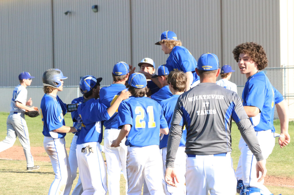 The JV baseball team celebrates a walk off win last year./Ron Espinola • The Brand
