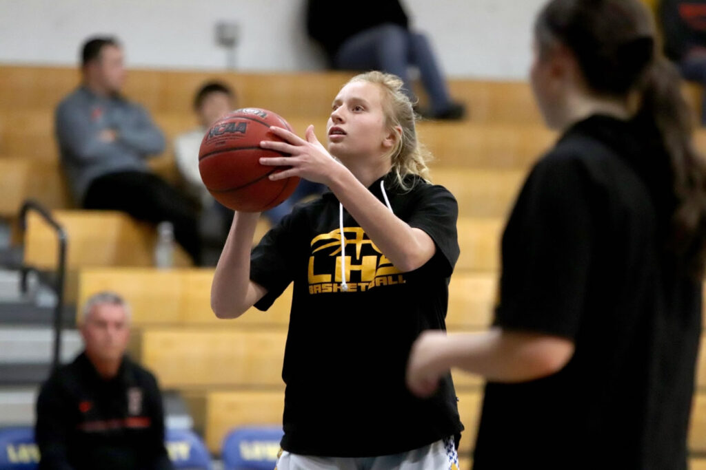 Alexis Olson attempts a three-point shot during warm ups. /Bree Dunckhorst • The Brand