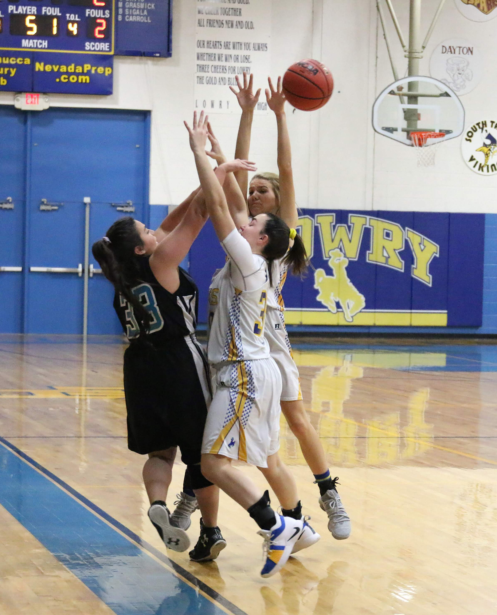 Jovi Kuskie and Macy DeLong trap a North Valleys player./Clarissa Olson • The Brand