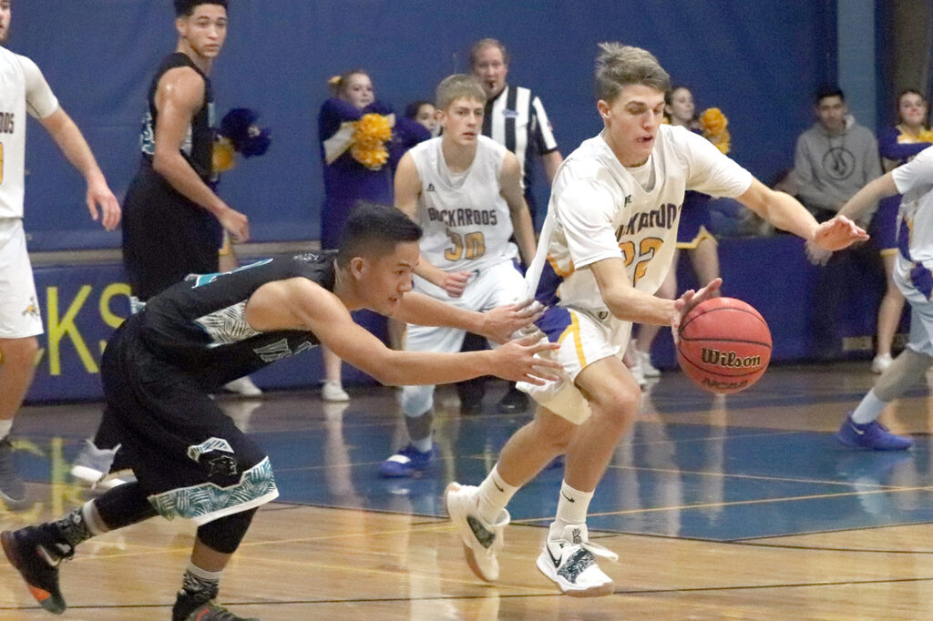 Brendan Domire takes the ball down the court./Mackie Grady• The Brand