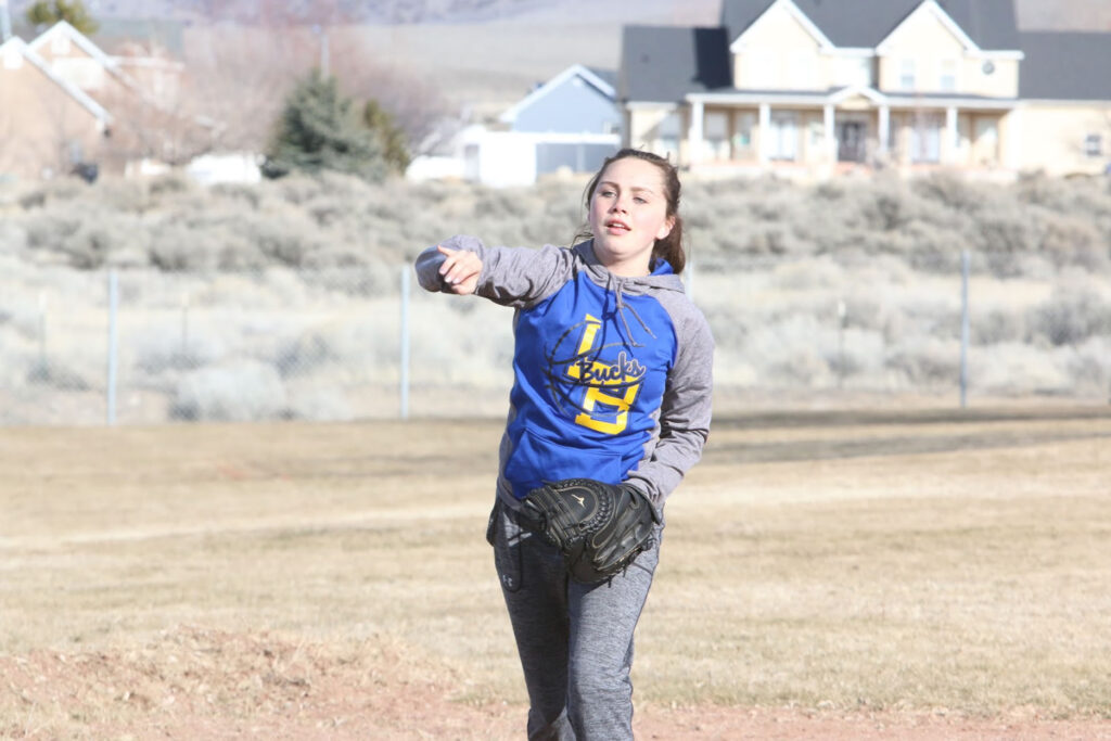 Cadance Mercado throws a softball./Ron Espinola • The Brand