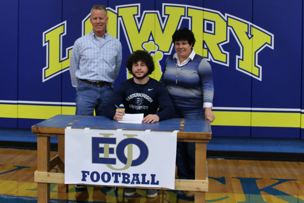 Gratian Dawson signs with EOU football with his father, Jeff, and mother, Marie-Jean, in attendance. /Courtesy • Gratian Dawson