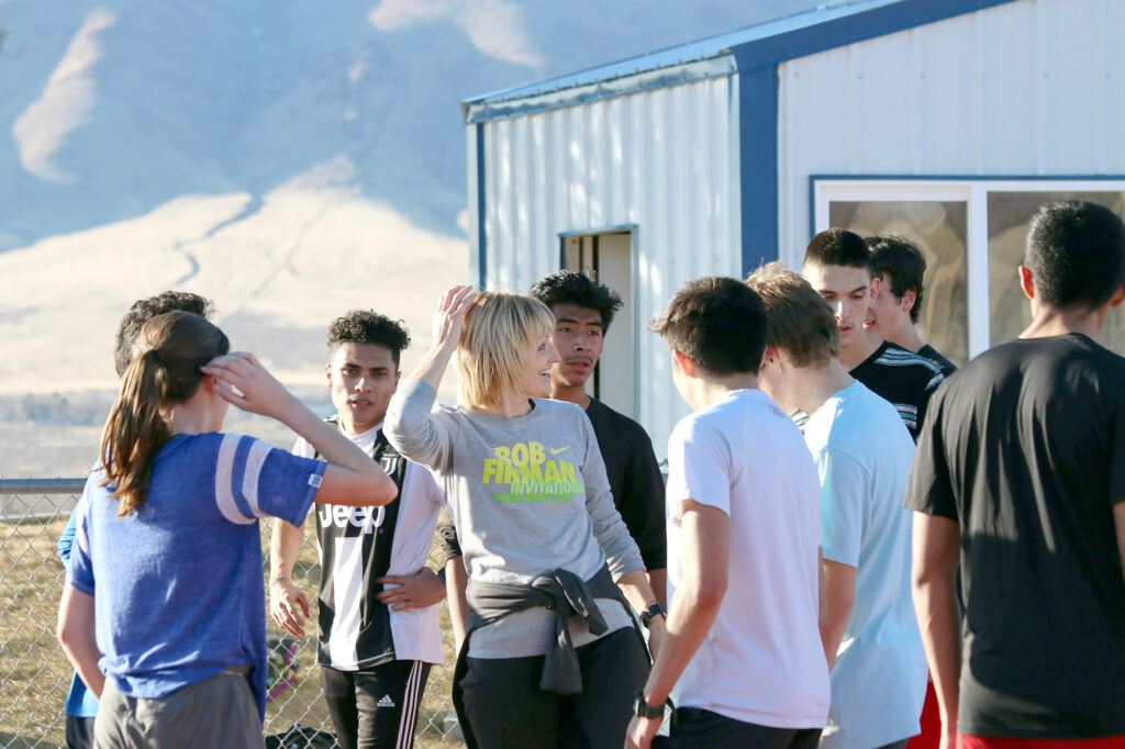 Coach Kitty Norcutt surrounded by her athletes./Araceli Galarza • The Brand