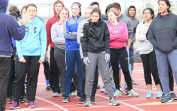 Coach Ray Garrison instructs sprinters at practice including./Ron Espinola • The Brand