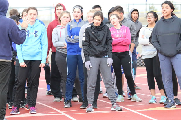 Coach Ray Garrison instructs sprinters at practice including./Ron Espinola • The Brand