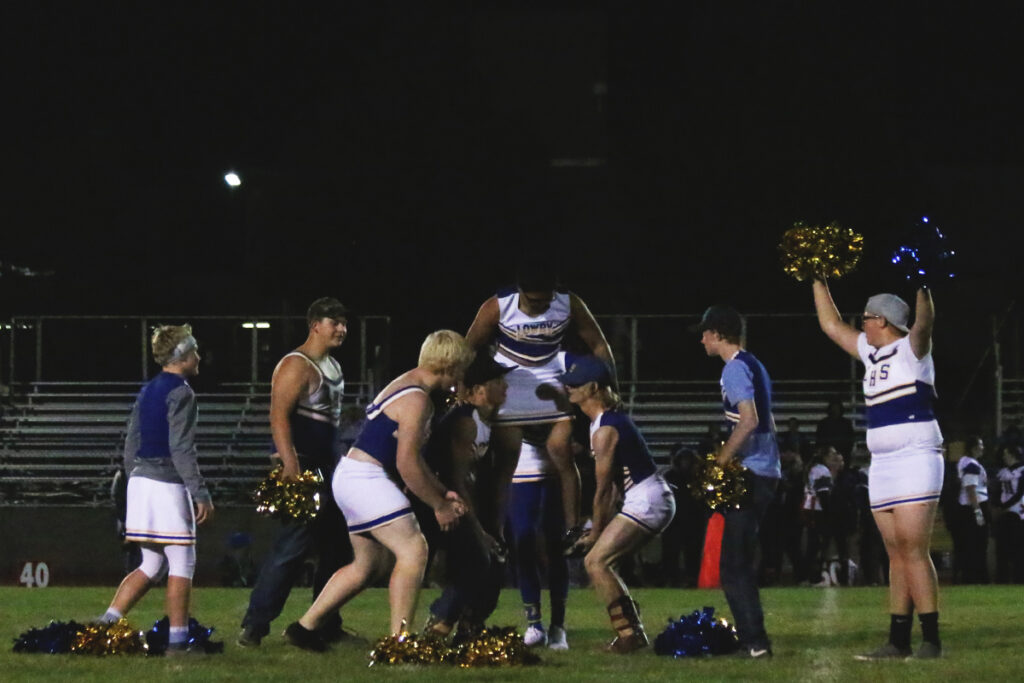 The male cheerleaders lift up Rudy Combes./ Tara Bourland • The Brand