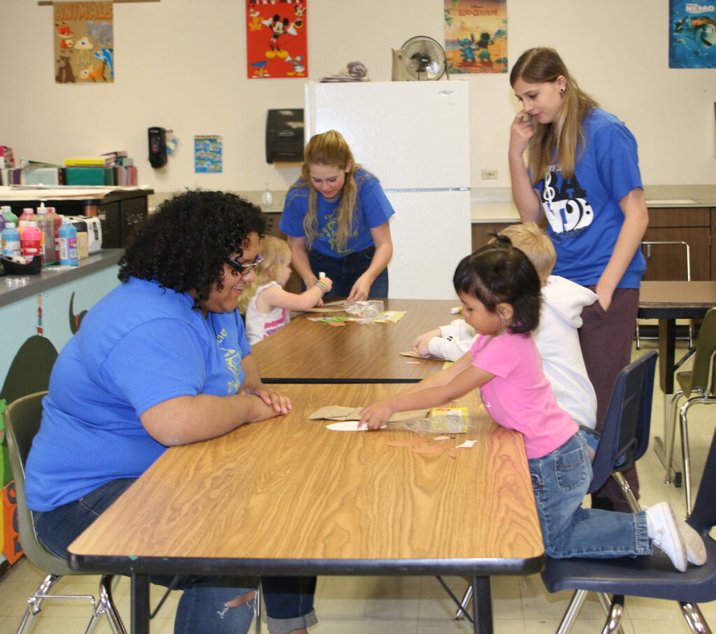 High school students (Left) Maya Covarrubias, (Center) Brooklyn Backus and (Right) Gaven Ross with their students./Kaity Sample • The Brand